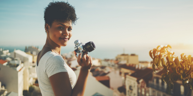 Jornalista em um terraço com uma câmera fotográfica