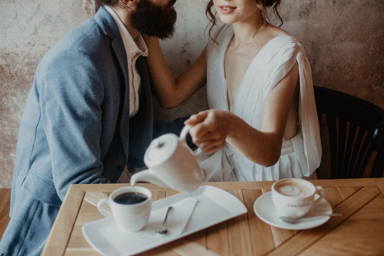 Casal conversando enquanto mulher enche a xícara de café