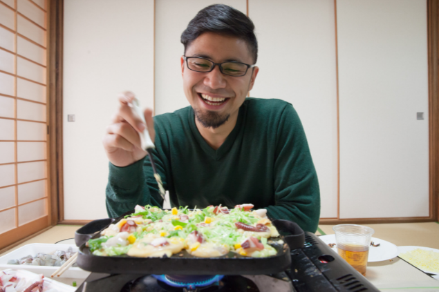 Homem feliz cozinhando sozinho