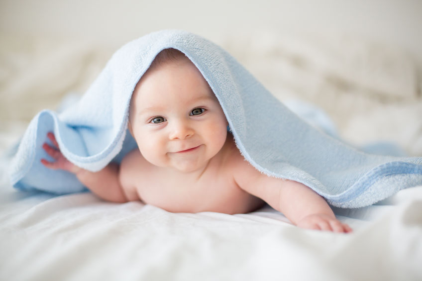 Bebê sorrindo com toalha na cabeça