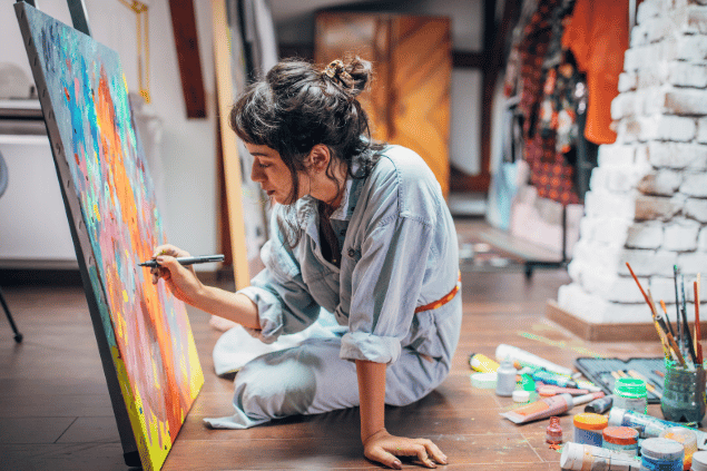 Mulher pintando quadro em colorido. 