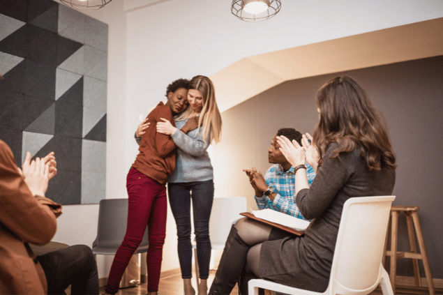Mulheres se abraçando em um grupo de terapia