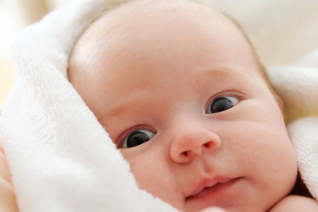 Imagem de um recém-nascido envolto em uma coberta branca