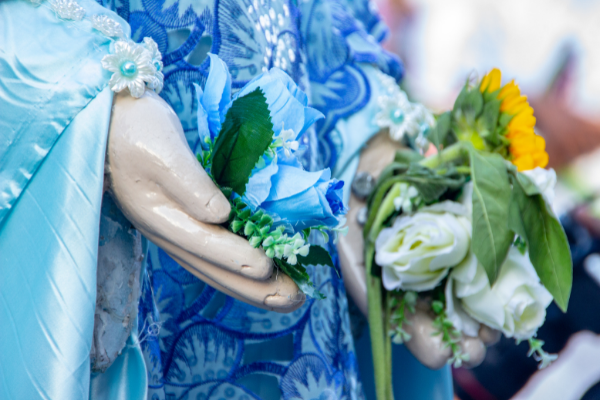 Mãos de escultura de Iemanjá segurando flores,