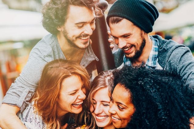 Imagem de um grupo de amigos se abraçando e sorrindo