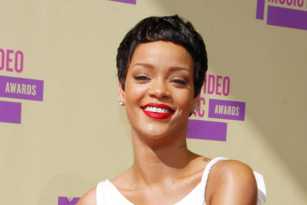 Rihanna sorrindo olhando para frente com cabelo curto 