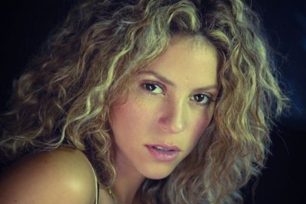 Shakira olhando para frente séria com cabelo em seu rosto