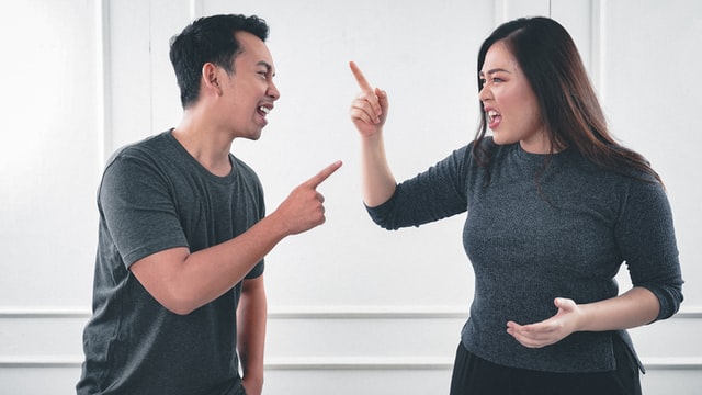 Homem e mulher asiáticos discutindo.