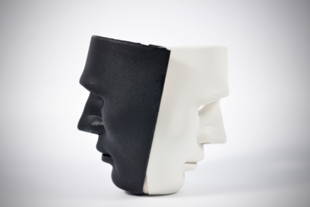 Duas máscaras de costas uma para outra, demonstrando comportamentos diferentes