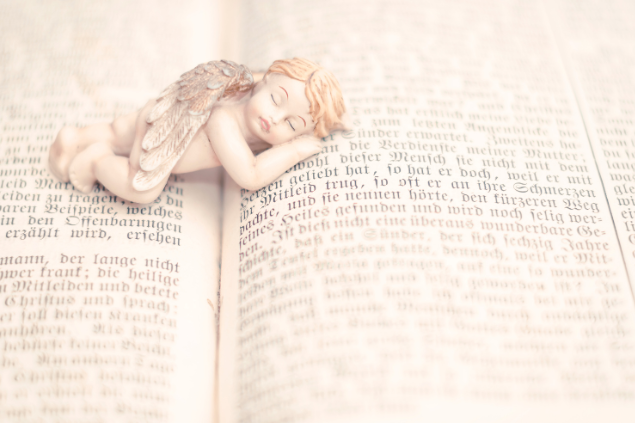 Estátua de anjinho deitado em um livro