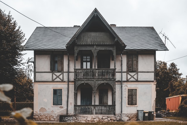 Casa cinza com detalhes de madeira escura.