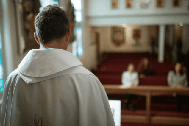 Padre virado de costas enquanto conduz uma missa