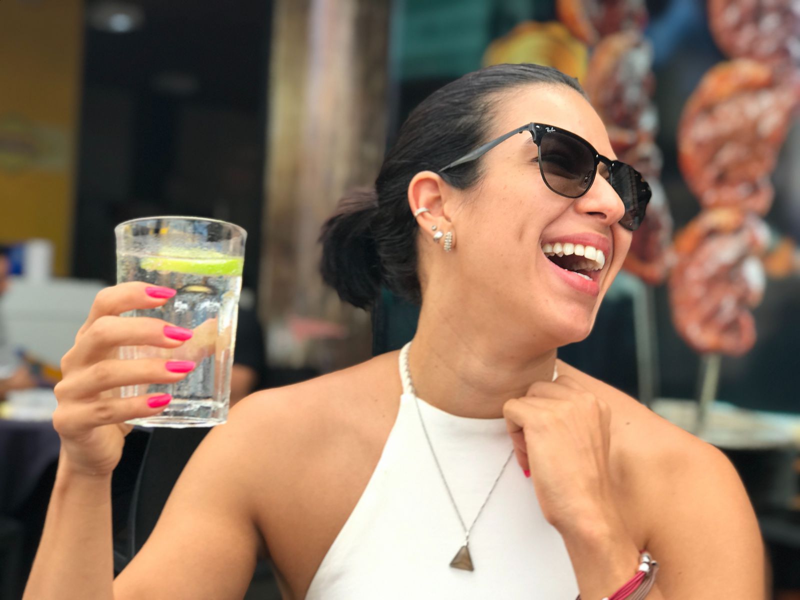 Mulher segurando copo com bebida e sorrindo
