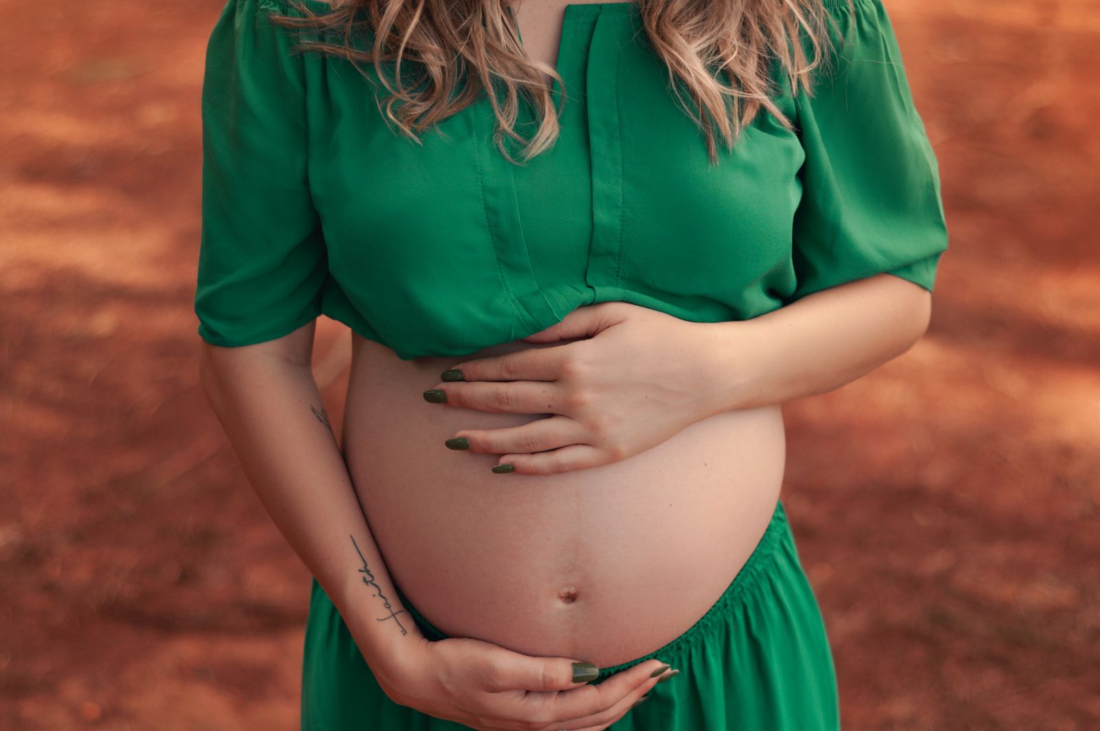 Mulher grávida com suas mãos na barriga