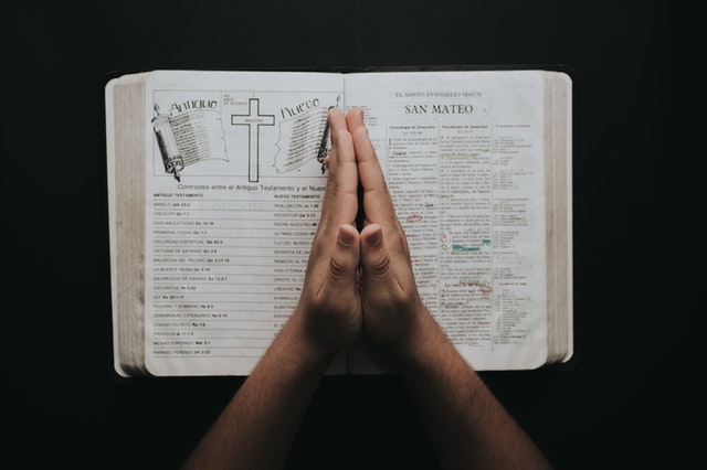 Pessoa com as mãos sobre uma Bíblia.